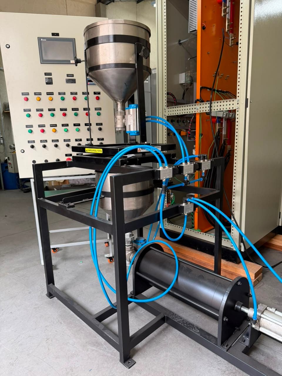 Máquina dosadora com funil de aço inox, cilindro pneumático e painel de comando com IHM ao lado