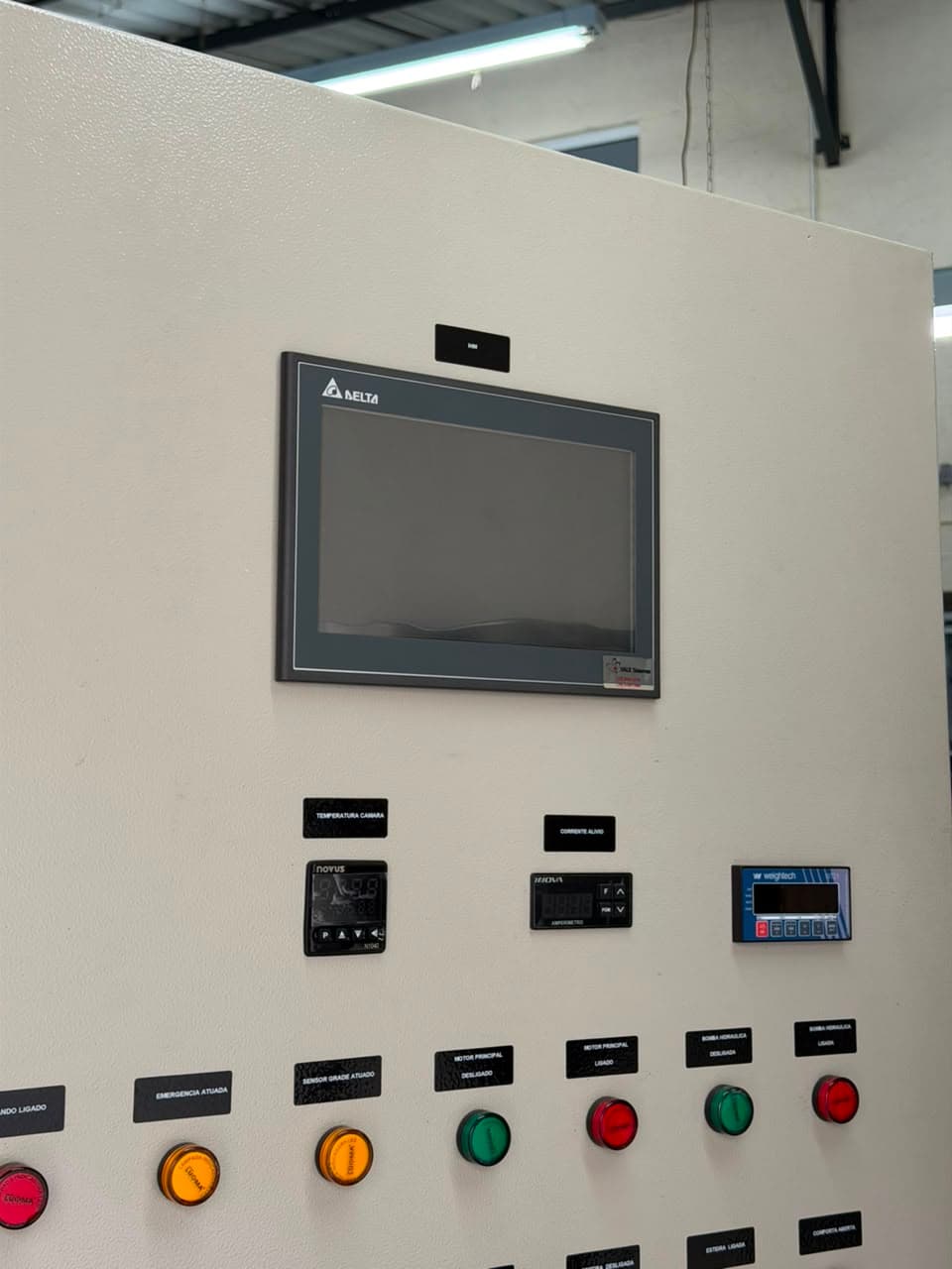 Detalhe de IHM com controlador de temperatura, amperímetro e indicador de peso instalados na porta do painel